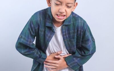 Child holding stomach in pain indicating possible gastrointestinal discomfort.