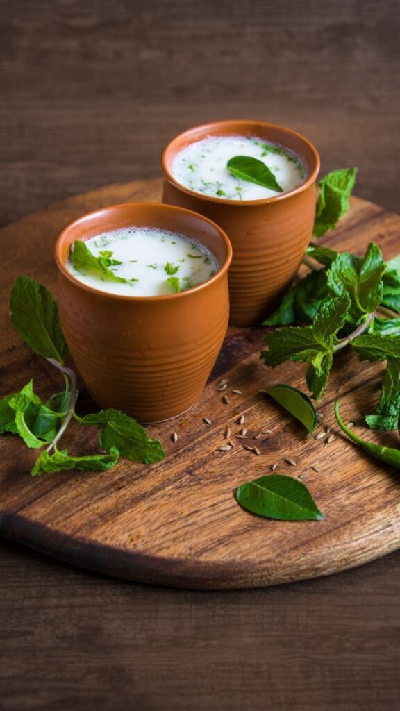 Glass of traditional pink Solkadhi made with kokum and coconut milk, served beside dried kokum on a wooden table, highlighting its digestive and probiotic benefits.